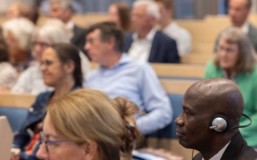 Luisteraars zitten in kerkbanken.