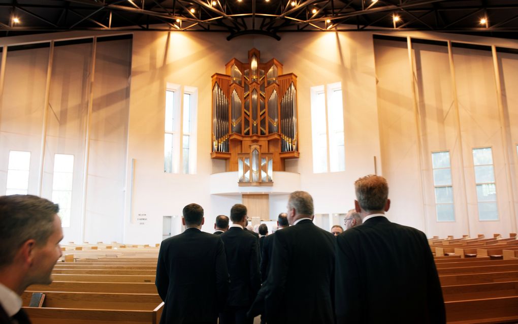 Diakenen loopen kerk in.