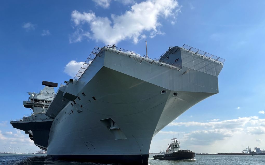 Het Britse vliegdekschip HMS Prince of Wales glijdt langzaam de haven van Rotterdam uit. Vier sleepboten escorteren het reusachtige oorlogsschip. beeld RD