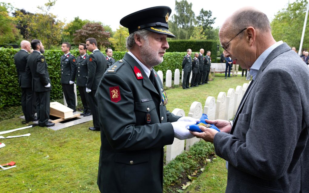 Militair overhandigt onderscheidingsteken.