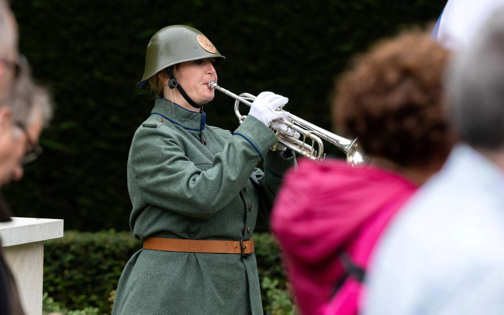 Vrouw blaast op trompet.