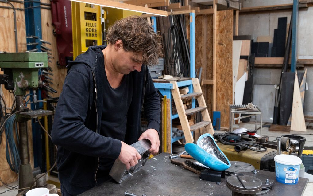 De kunstenaar is bezig in zijn atelier.