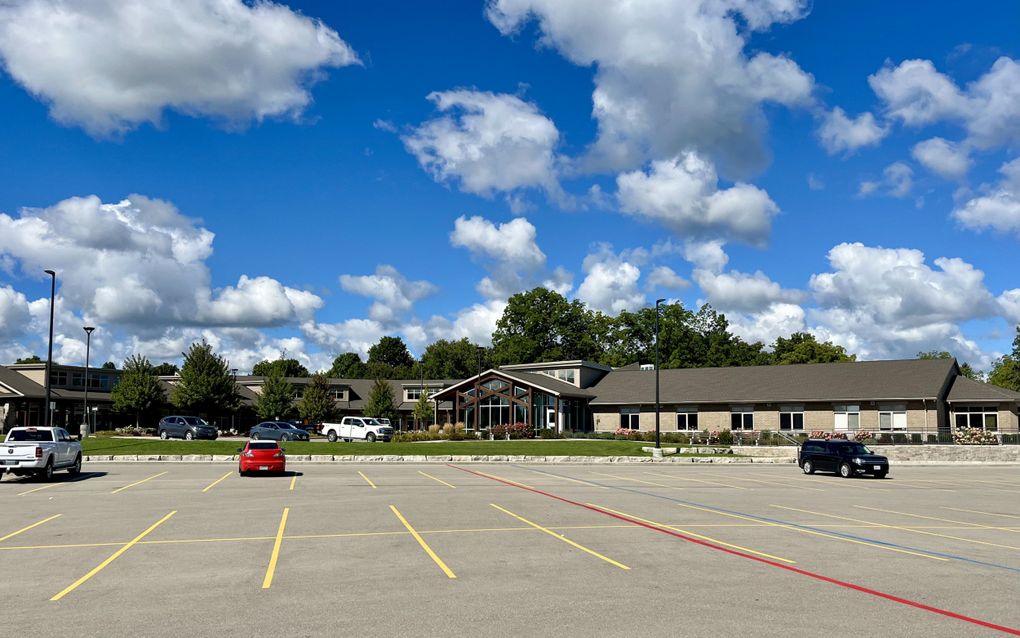 Parkeerplaats met erachter een tehuis.
