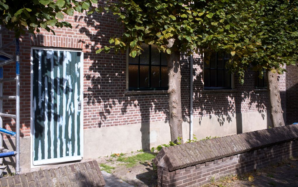 Muur met bomen en een deur.