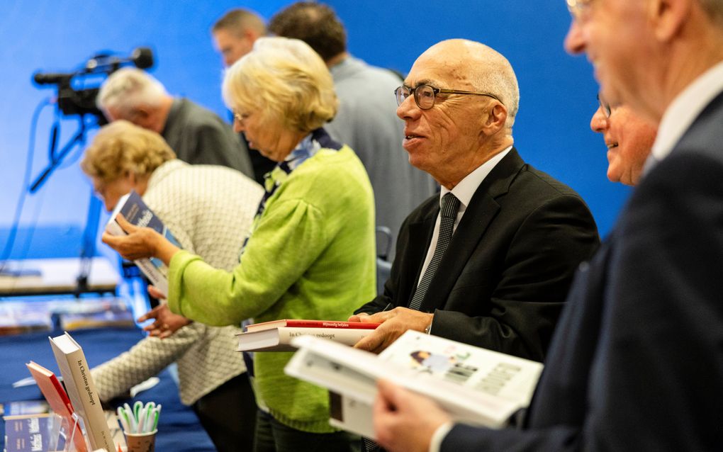 Mannen en vrouwen met boeken in hun handen.
