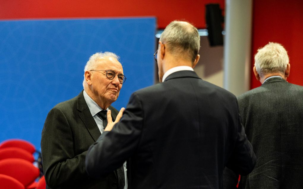 Mannen in donkere pakken praten met elkaar.