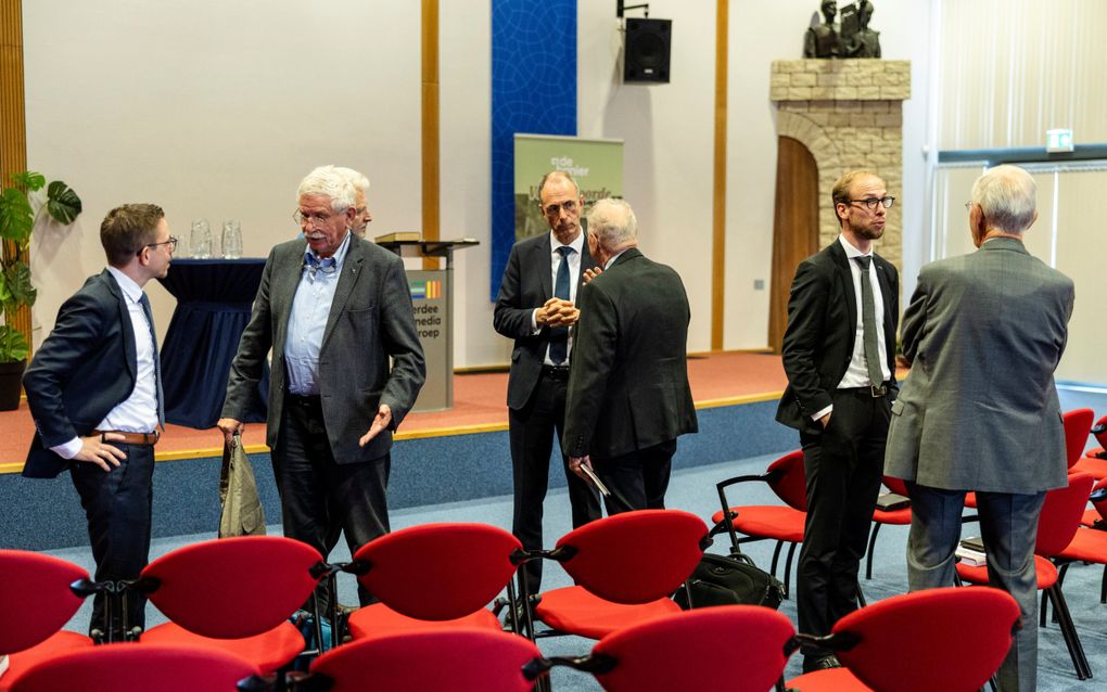 Mannen in donkere pakken praten met elkaar.