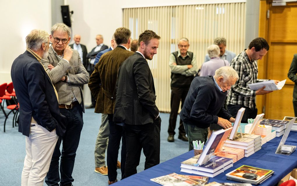 Mannen in donkere pakken praten met elkaar.