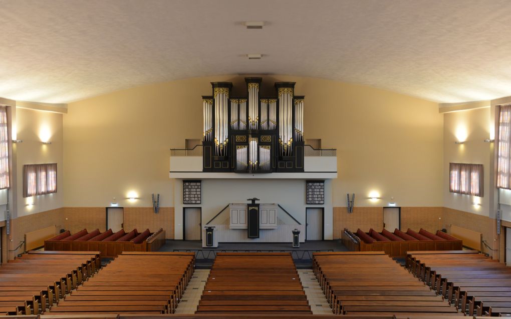 De huidige kerkzaal, met overal houten banken; tegen de achterwand de preekstoel en daarboven het orgel.