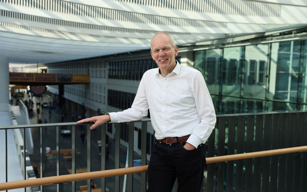 Man in wit overhemd op een loopbrug.