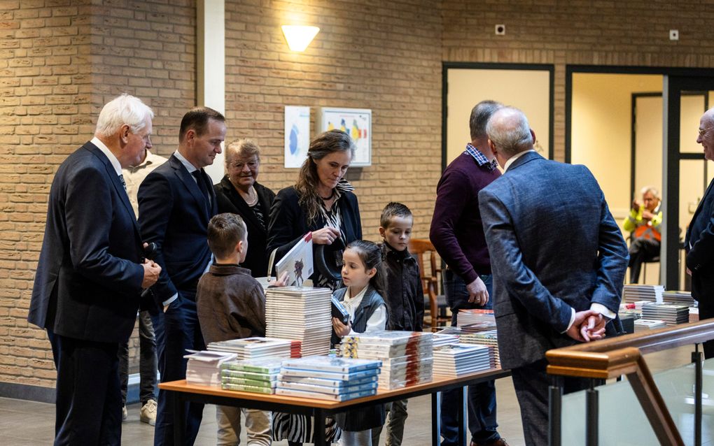 Groep mensen staat bij boekentafel.