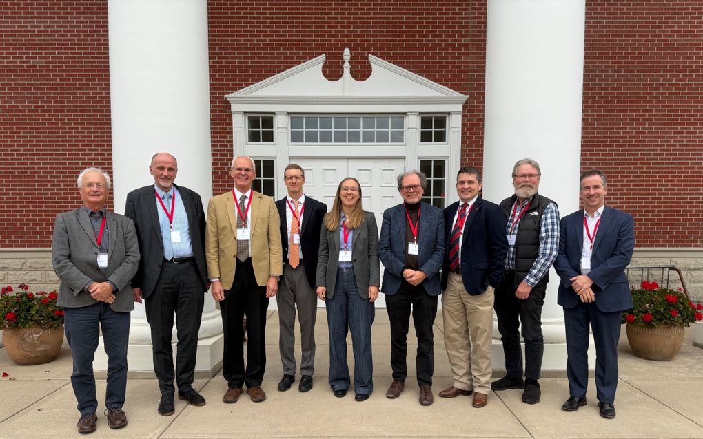 Een groep mensen voor een gebouw van rode bakstenen.