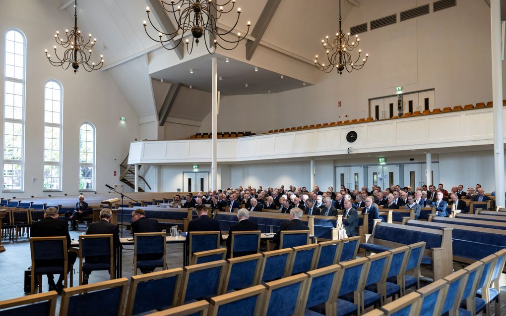 Een groep mensen zit op kerkbanken in een kerkzaal.