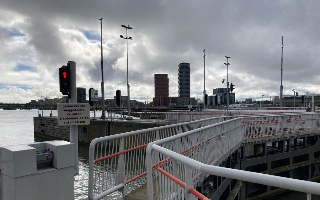 Sluizen in Amsterdam. Op de andere oever staat wat hoogbouw. De lucht erachter is bewolkt. 