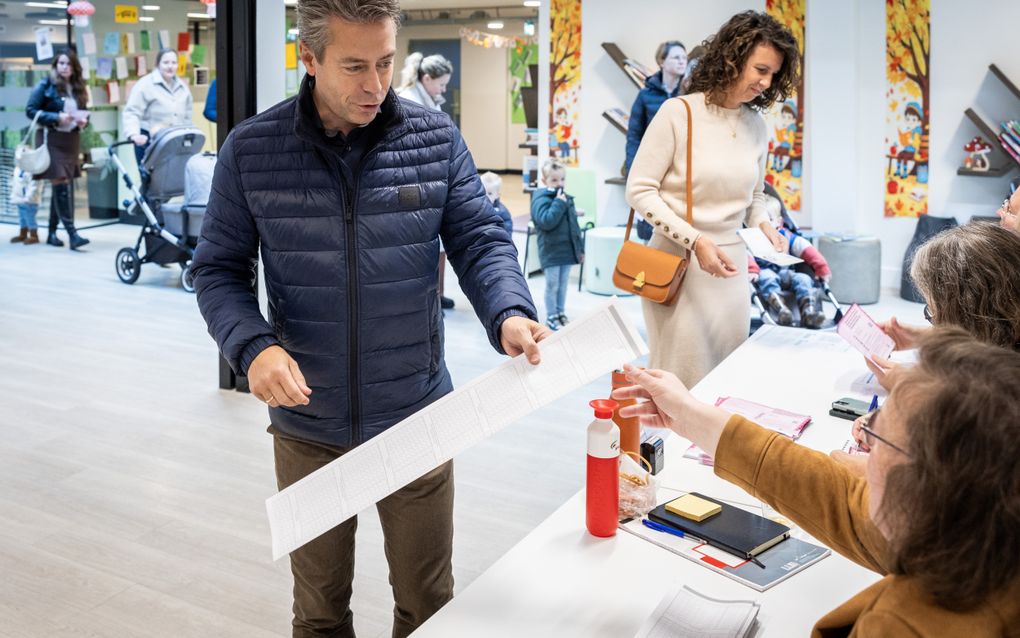 Chris Stoffer en zijn vrouw staan voor een bureau en krijgen een formulier uitgereikt