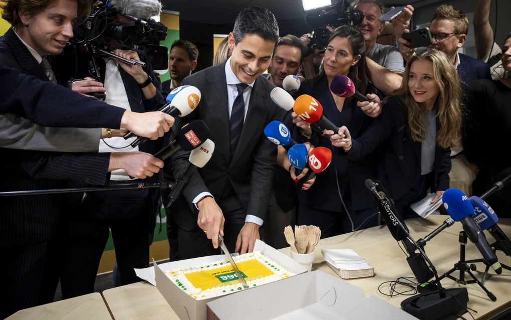 Rob Jetten snijdt taart aan, om hem heen journalisten