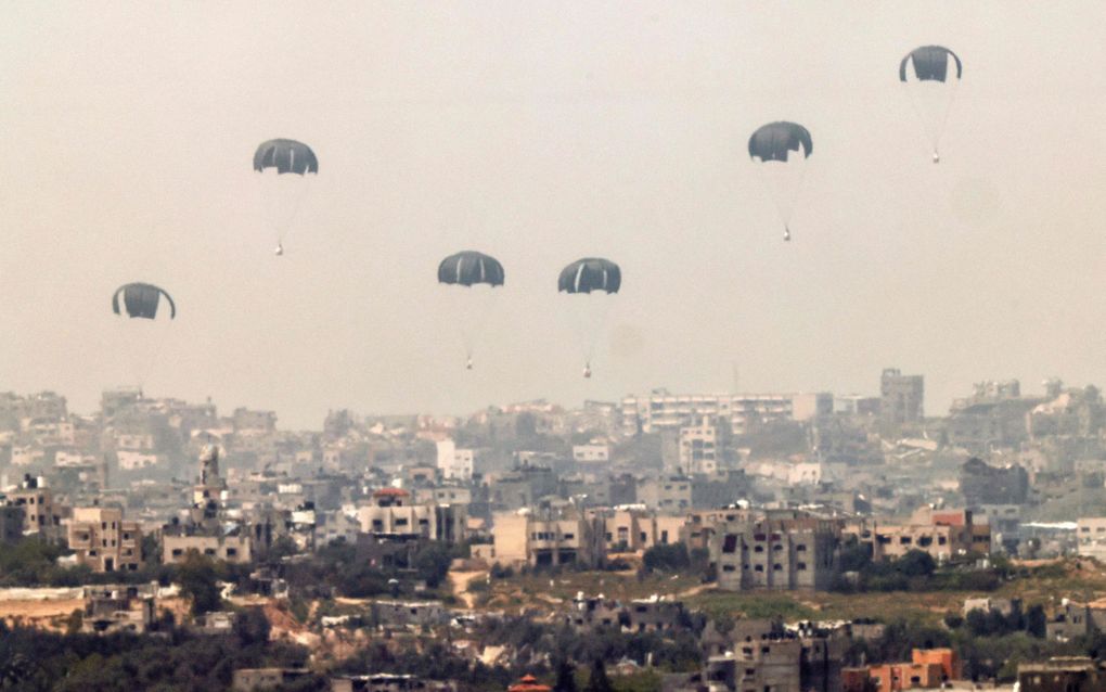 Foto genomen vanaf de Israëlische zuidgrens, donderdag: humanitaire hulp vanuit de lucht boven de Gazastrook. beeld AFP, Jack Guez