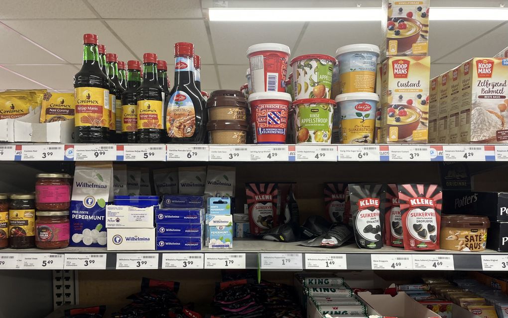 Schappen in een supermarkt met typische Nederlandse producten, zoals Wilhelmina pepermunt.