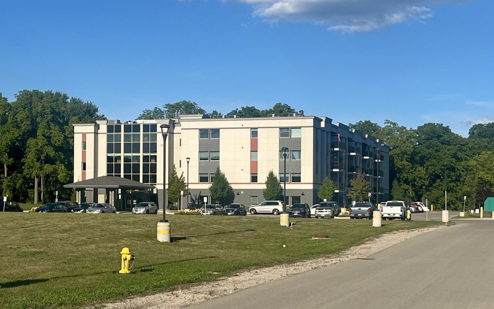 Rechthoekig appartementencomplex met een grasveld ervoor.