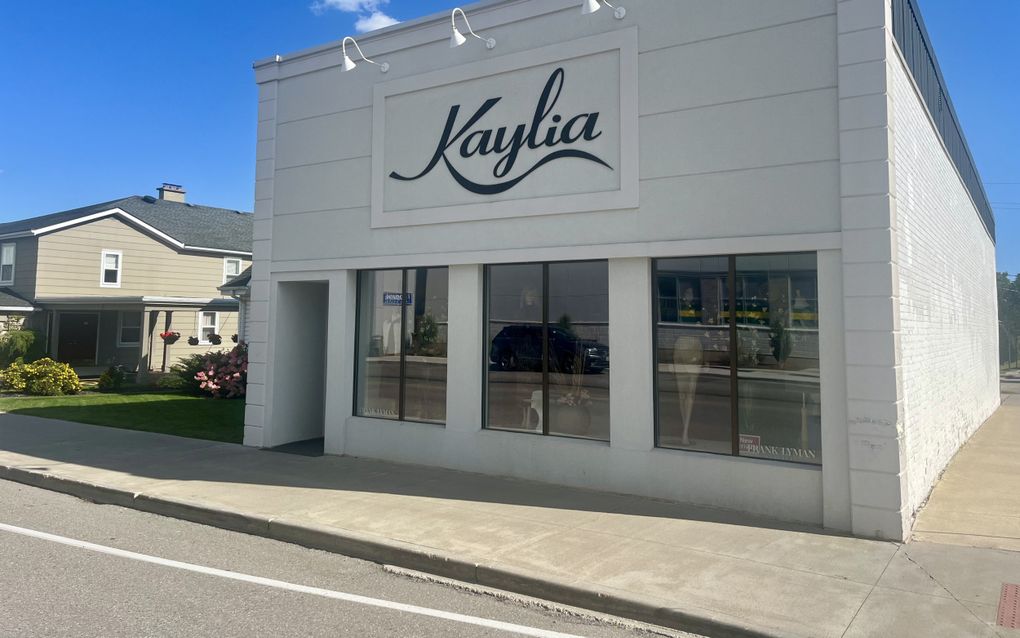 Een rechthoekige, witte kledingwinkel van buitenaf gezien.