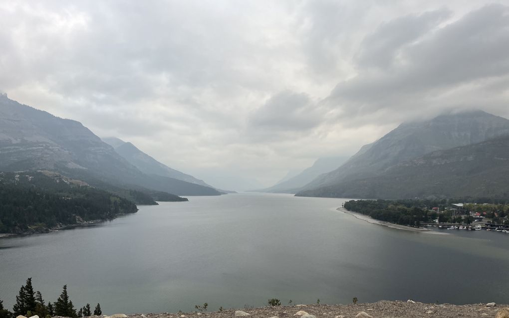 Een groot meer met bergen eromheen in de mist.