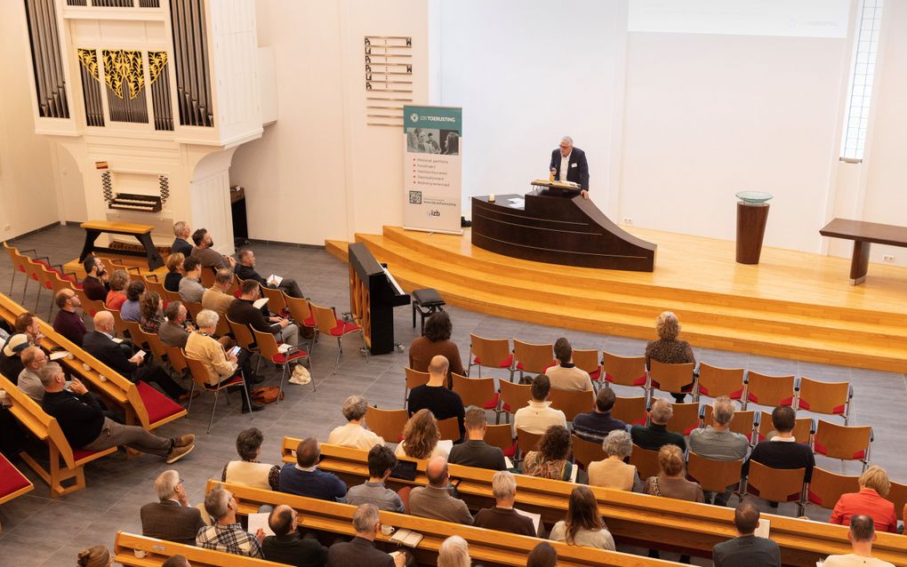 Foto vanaf de galerij, met mensen in de banken. Links het orgel.