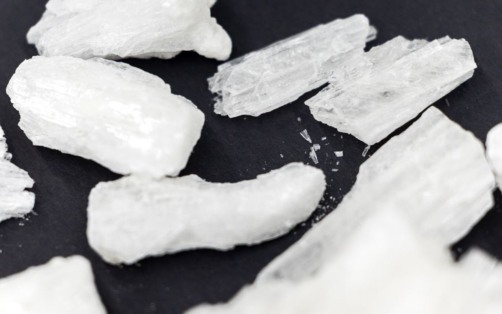 Doorzichtig-witte stukjes liggen op een zwarte ondergrond.