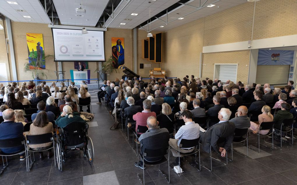 Zaal vol mensen, op de rug gezien.