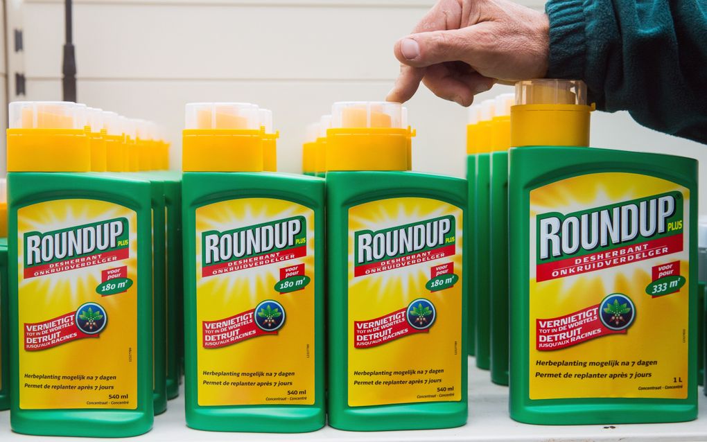 Flessen onkruidverdelger 'Roundup' liggen op een schap in een tuinwinkel. 