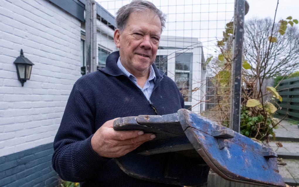 Man in blauwe trui, met oud sleetje.