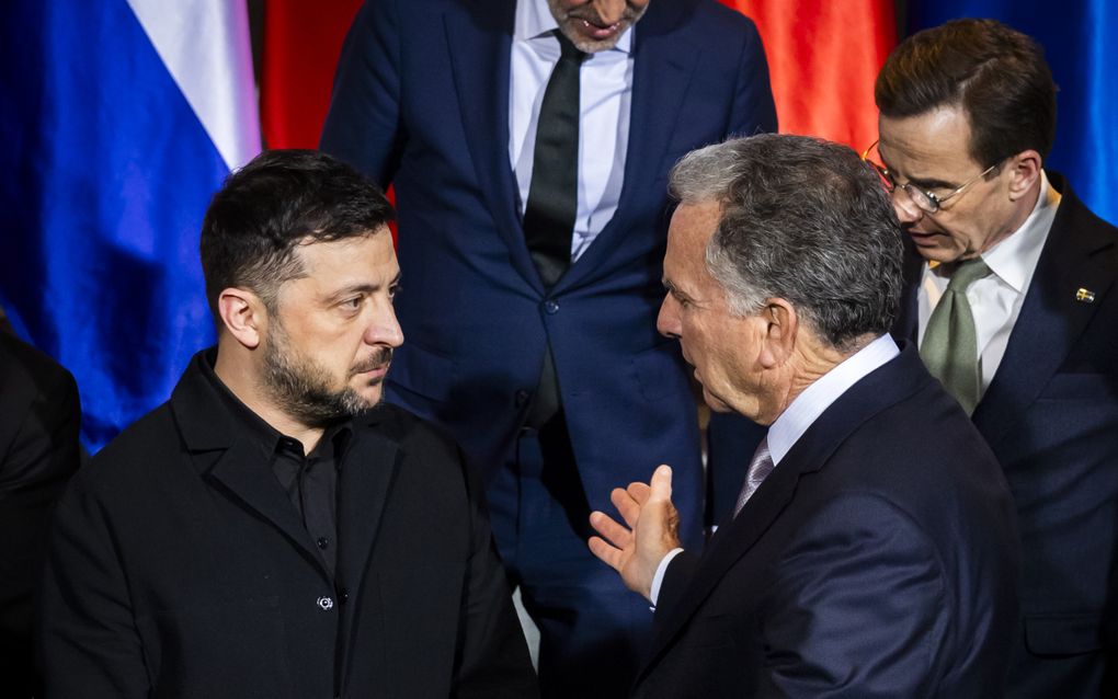 Twee mannen in donkere kleding praten met elkaar.