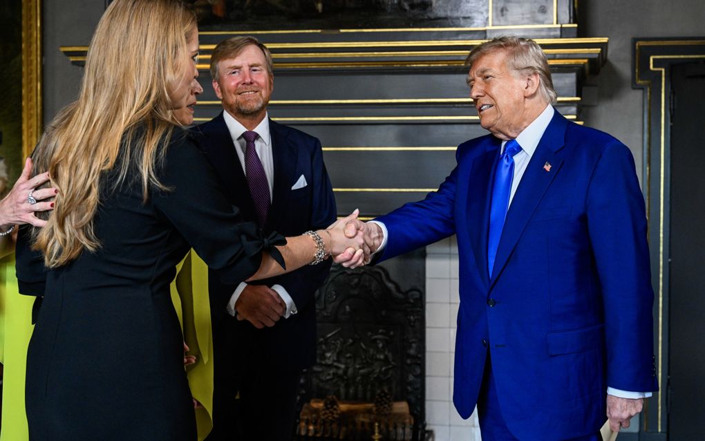 Man schudt jonge vrouw de hand. Man op de achtergrond kijkt lachend toe.