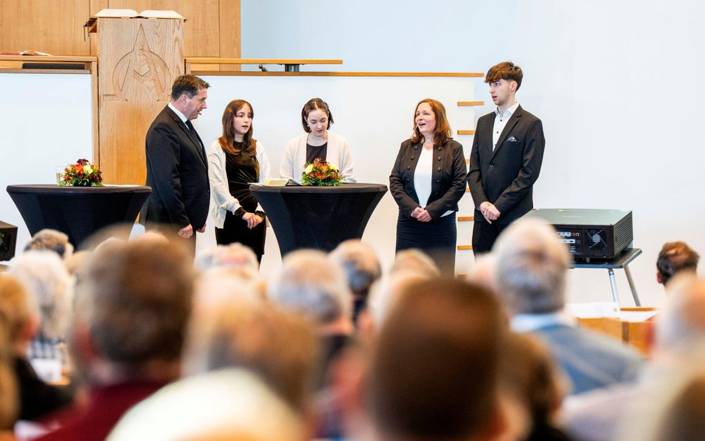 Man, vrouw, zoon en twee dochters zingen.