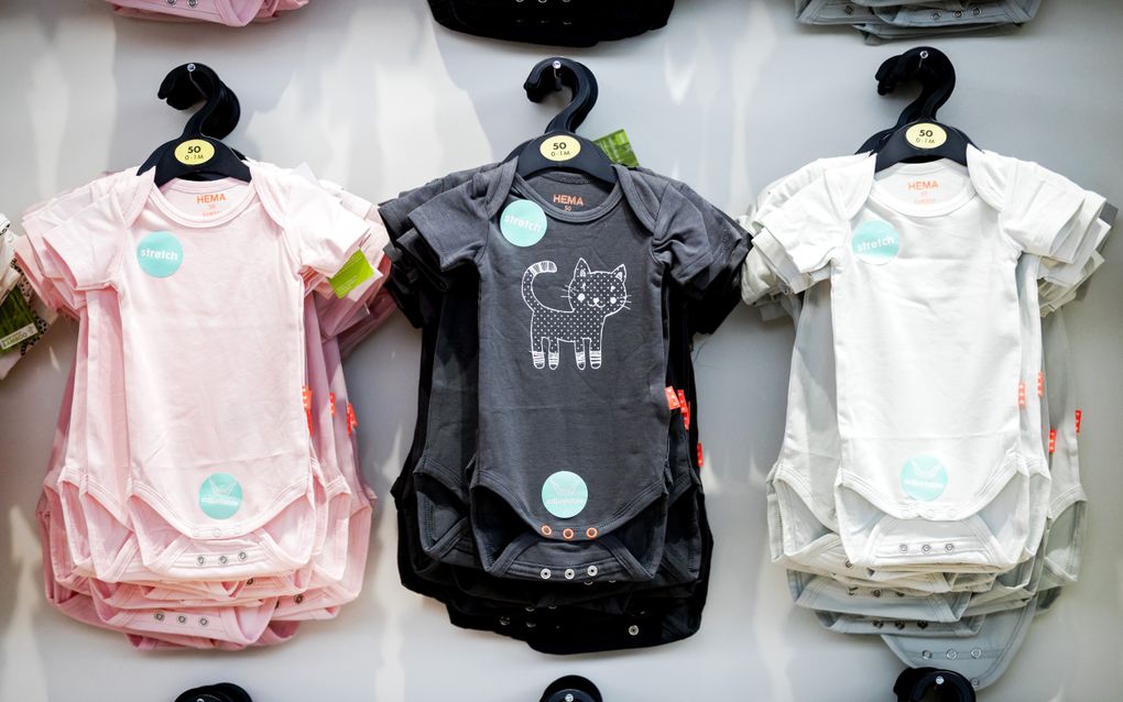 Drie rijtjes met babyrompertjes aan een hangertje.