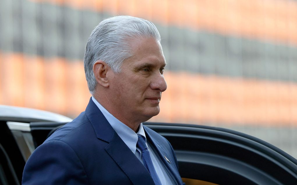 Man met grijs achterover gekamd haar draagt een blauw maatpak.