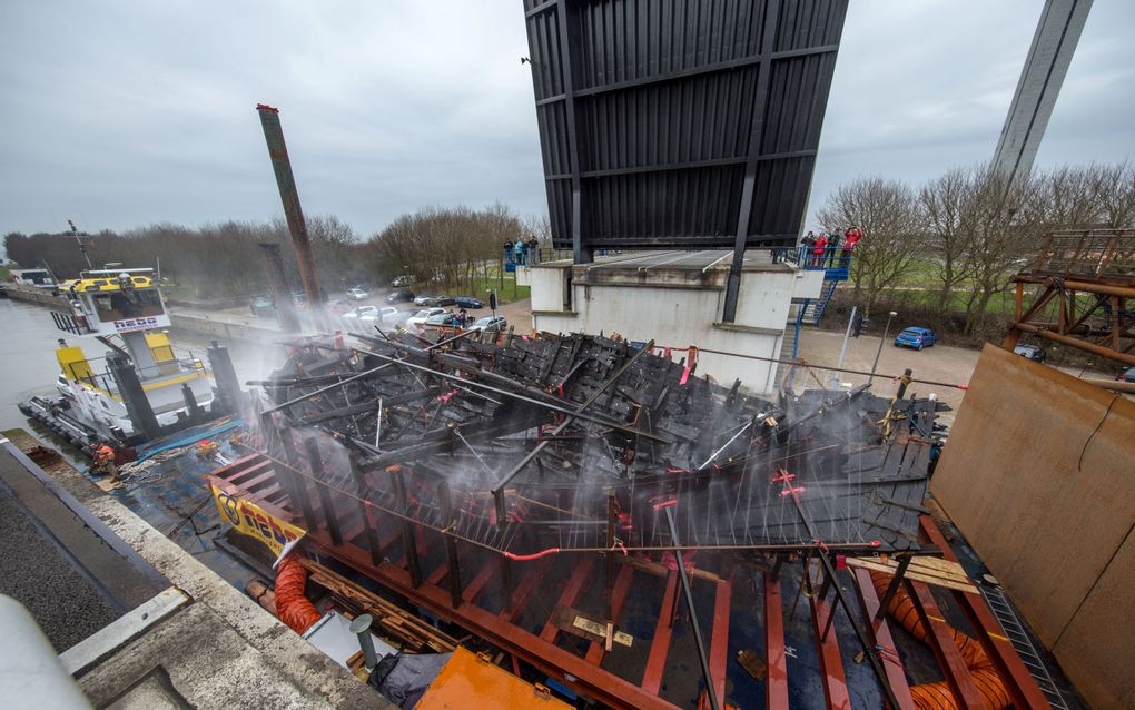 Dampend hout op schip dat onder openstaande brug door vaart.