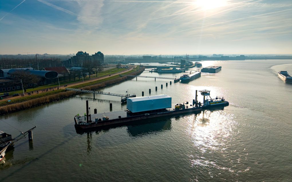 Witte ‘doos’ op ponton. Zon weerspiegelt in het water.