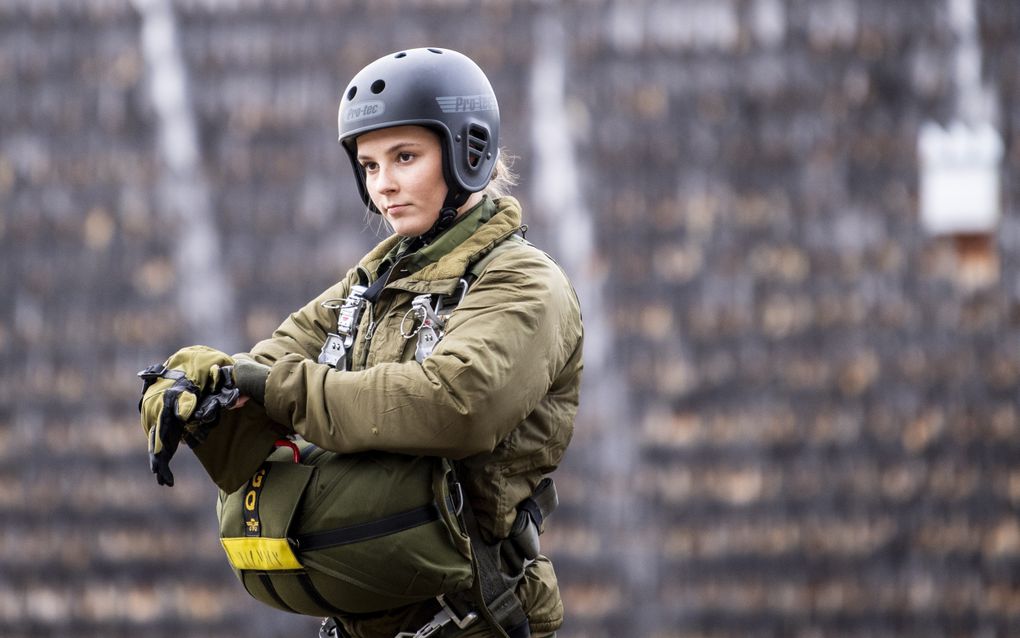Jonge vrouw in militair uniform en helm.