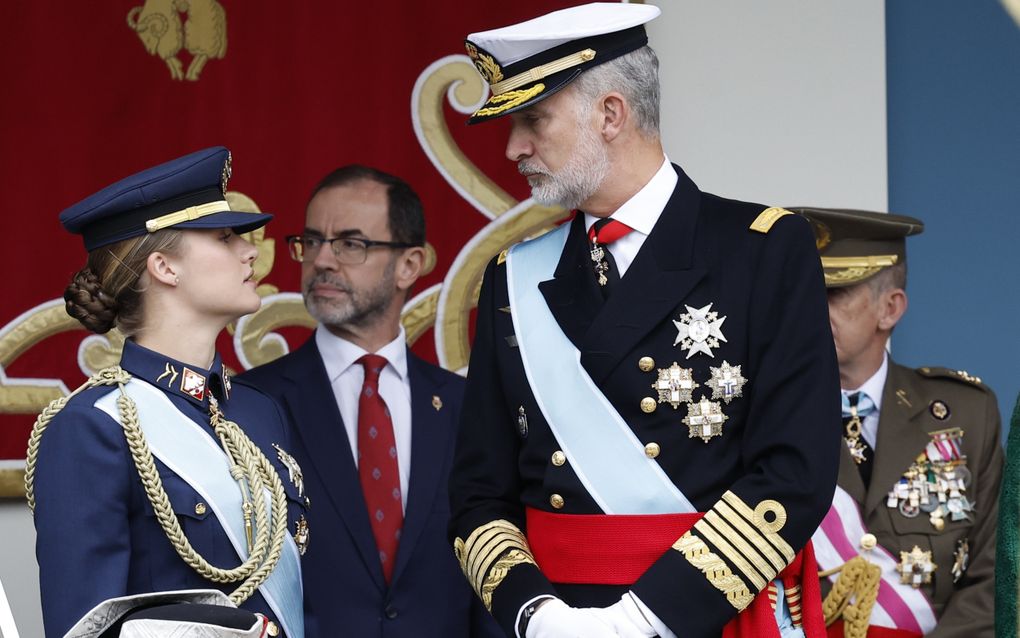 Jonge vrouw in marine-uniform kijkt naar man in militair ceremonieel uniform.