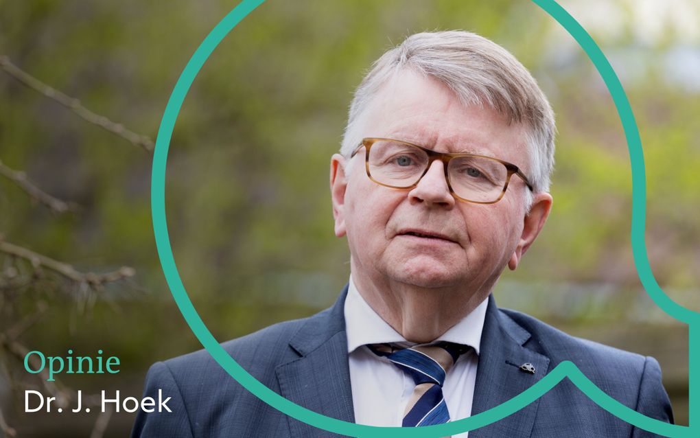 Foto van dr. J. Hoek, met bril, pak, gekleurde stropdas.