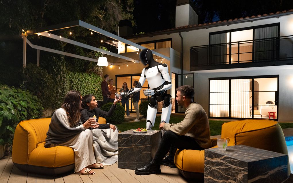 Mensrobot in witte en zwarte kleuren geeft een glas met drinken aan een vrouw op een gele bank. Een andere vrouw en een man kijken toe. 