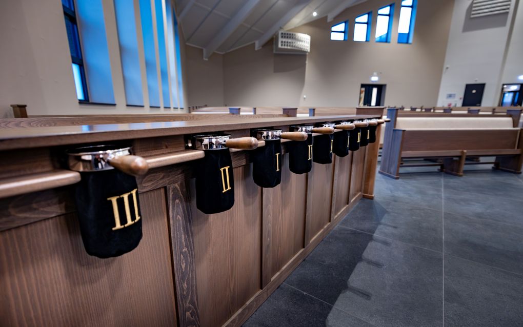 Een bank met daaraan collectezakken.