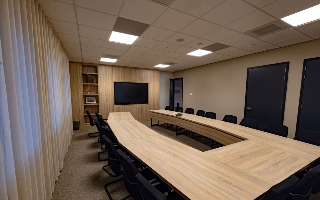 Een grote ruimte met een lange tafel en stoelen.