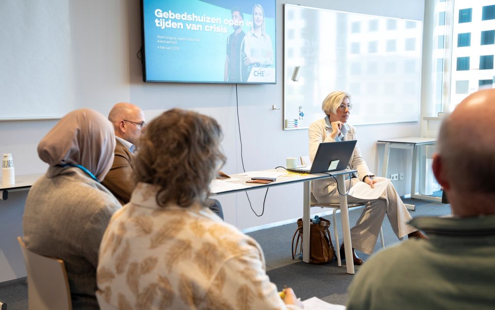 Een aantal mannen en vrouwen zitten op stoelen in een cirkel.