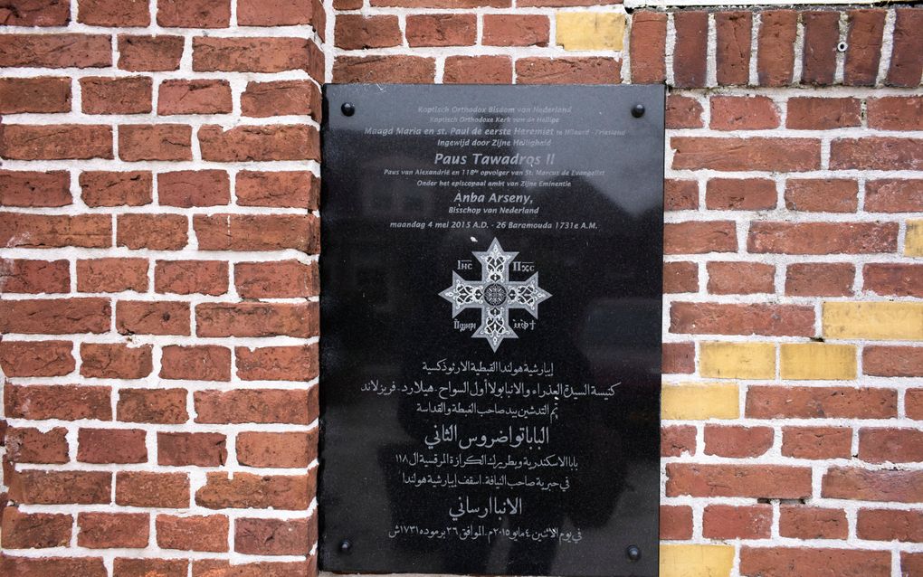 Zwarte marmeren plaat aan de gevel van een kerk. Daar staat onder meer op dat de koptische paus Tawadros II op 4 mei 2015 de voormalige gereformeerde kerk inwijdde