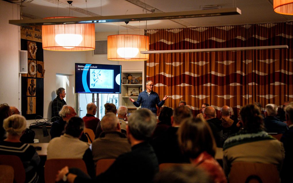 Mensen in een zaal en een beeldscherm