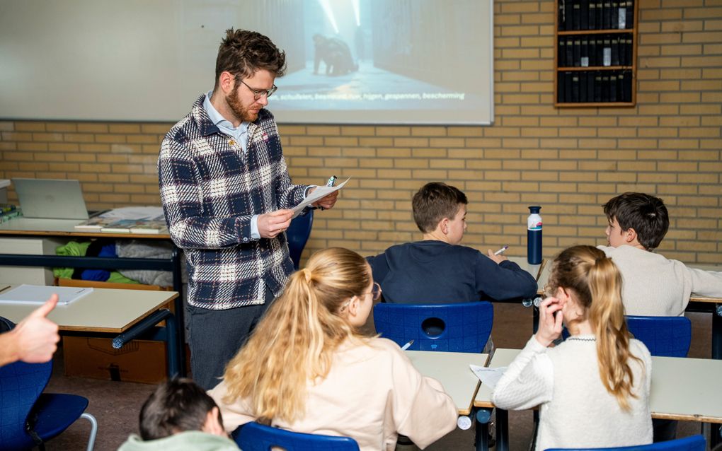 Een man kijkt op een wit vel papier.