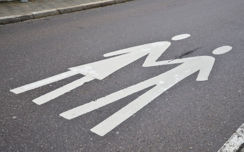 Witte markering op grijze asfaltweg met symbolen van man en vrouw