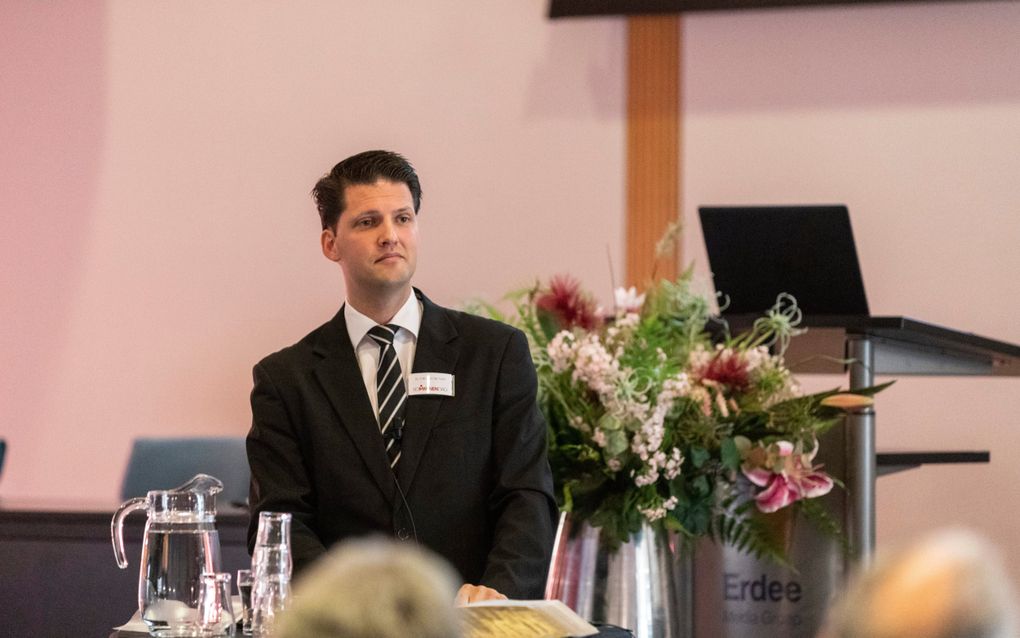Dominee Van der Toorn, een man met zwart haar, zwart pak.