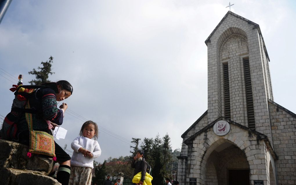 Een jonge Hmong-moeder op een pleintje voor een kerk in Sapa, in het noorden van Vietnam. beeld AFP, Hoang Dinh Nam